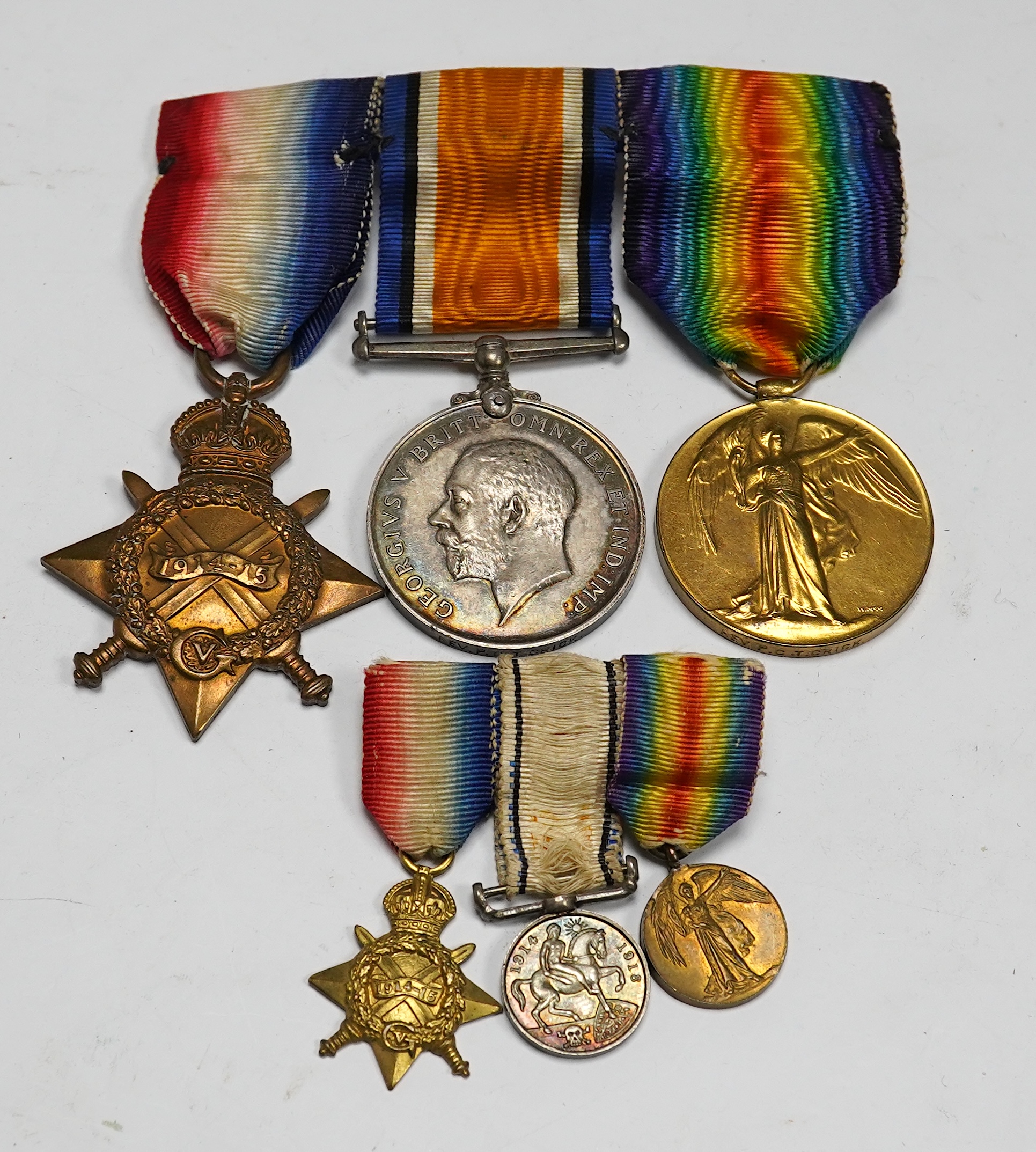 A First World War medal trio awarded to the Rev. P.C.T. Crick A.C.D., together with the miniature set. Condition - poor to fair.